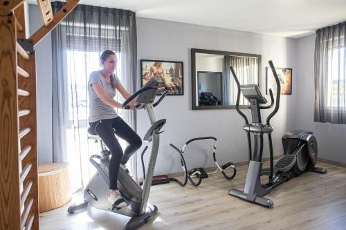 a woman riding on an exercise bike in a gym at Park Wilson Airport in Colomiers