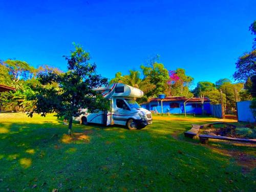a truck parked in a yard next to a house at Hostel e Camping Jardim da Mata in Chapada dos Guimarães