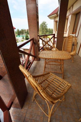 a group of wicker chairs sitting on a porch at Alpen Ville in Almaty
