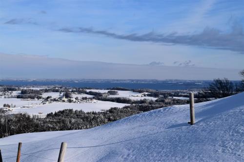 a snow covered hill with a fence on top of it at Chiemsee Chalet in Frasdorf