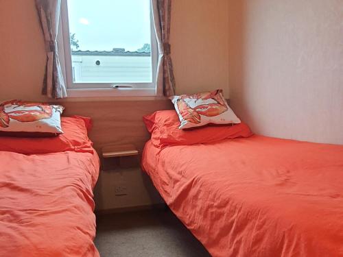 Duas camas num pequeno quarto com uma janela em The Wavering Knave em Starcross