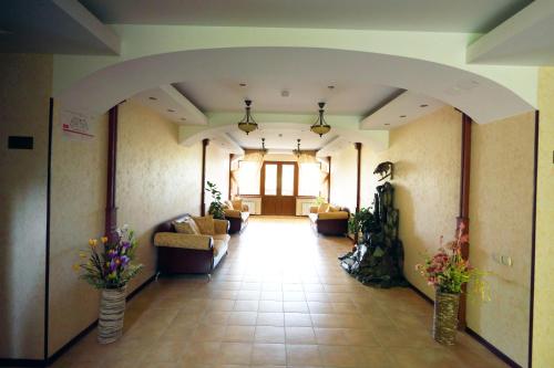 a hallway with couches and flowers in a building at Alpen Ville in Almaty