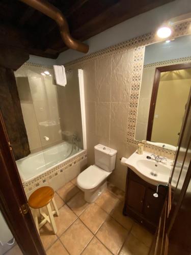 een badkamer met een toilet, een bad en een wastafel bij Apartamentos Rurales La Antigua Fonda in Candelario