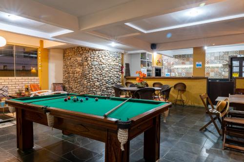 a pool table in a room with a bar at Pousada Dom Capudi in Bombinhas