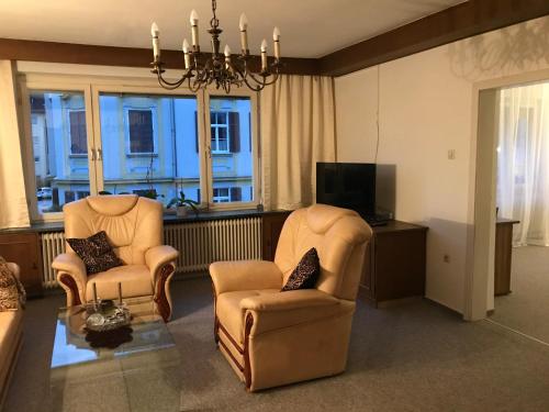 - un salon avec deux chaises et une télévision dans l'établissement Charmante Stadtwohnung im Zentrum von Leibnitz, à Leibnitz