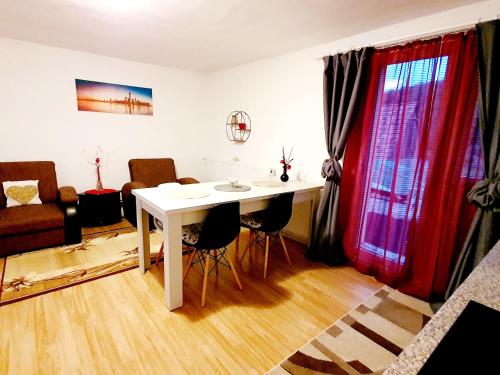 sala de estar con mesa blanca y sillas en Casa Maria, en Mălîncrav