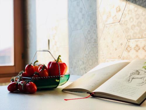 an open book and a bowl of cherries on a table at Ca' dei Armeni - San Marco Square in Venice