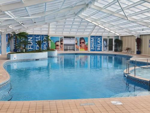 uma grande piscina com água azul num edifício em The Wavering Knave em Starcross