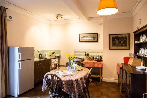 uma cozinha com uma mesa e um frigorífico em Butlers Quarters Apartment em Cairndow