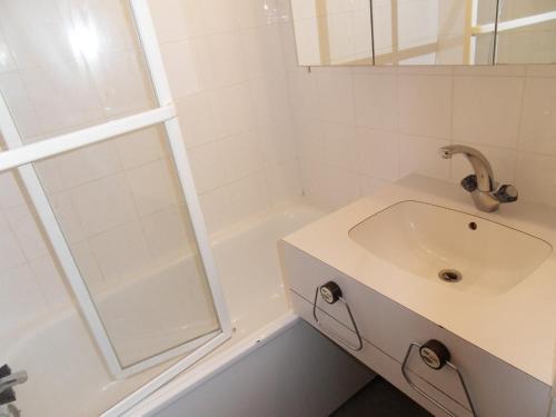 biała łazienka z umywalką i prysznicem w obiekcie travelski home classic - Résidence 3000 w mieście La Plagne