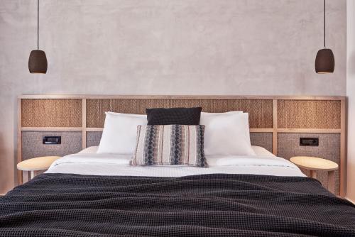a bedroom with a large bed with two chairs at Atlantica Marmari Palace in Mastichari