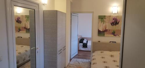 um corredor com um quarto com uma cama e um espelho em Апартамент Заря em Haskovo