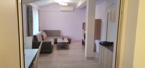 uma sala de estar com um sofá e uma mesa em Апартамент Заря em Haskovo