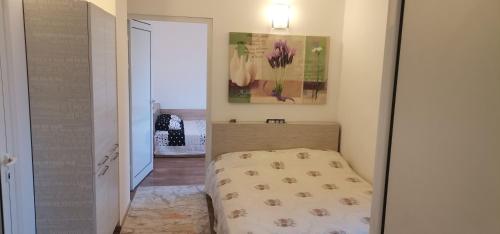 a small bedroom with a bed and a mirror at Апартамент Заря in Haskovo