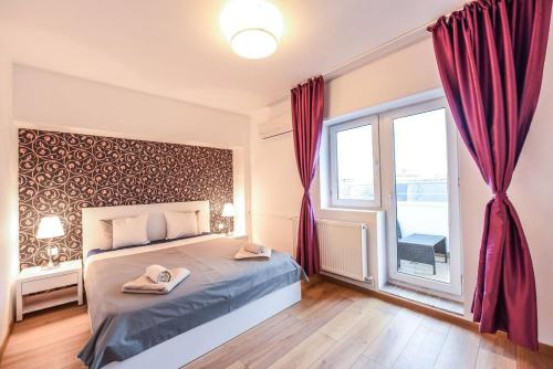 ブカレストにあるNew luxury flat at Unirii Square, Piata Uniriiのベッドルーム1室(赤いカーテンと窓付きのベッド1台付)