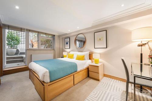 a bedroom with a bed and a desk and a window at Marylebone - Crawford Street by Viridian Apartments in London