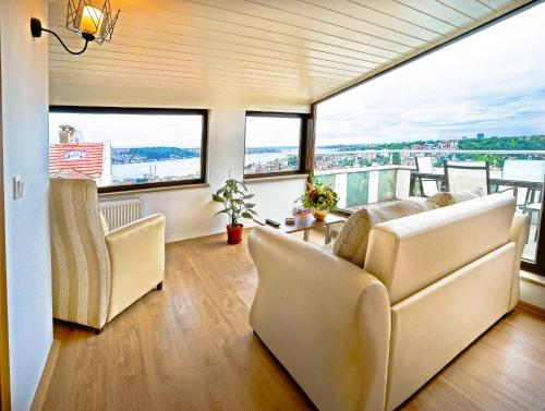 a living room with a couch and chairs and windows at Class Hotel Bosphorus With Jacuzzi in Istanbul