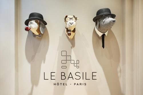 three stuffed dogs wearing hats and ties on a wall at Le Basile H&ocirc;tel in Paris