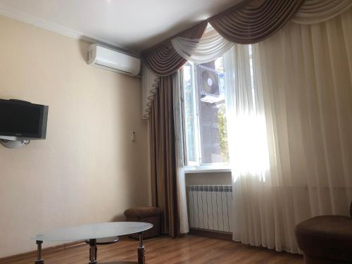 a living room with a table and a large window at Гаряча вода та опалення є без світла Elit Aparts on Pushkina WIFI in Dnipro
