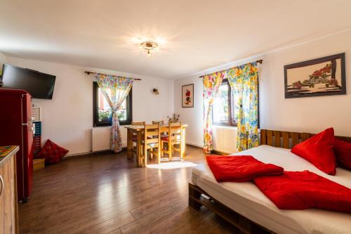 a bedroom with a bed with red pillows and a table at Sunset Cottage in Braşov