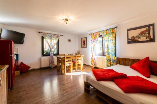 ブラショヴにあるSunset Cottageのベッドルーム1室(赤い枕とテーブル付きのベッド1台付)