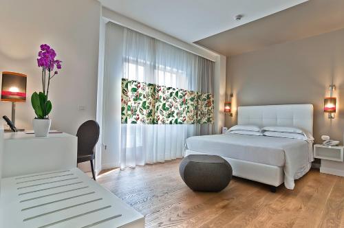 a white bedroom with a bed and a window at Hotel Caravel in Rome