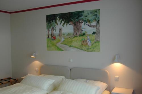 a painting hangs above a bed in a bedroom at Hotel Goldflair am Rathaus in Korbach