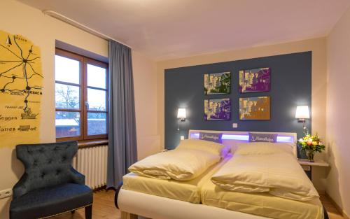 a bedroom with a bed and a chair at Hotel Goldflair am Rathaus in Korbach