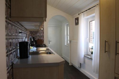 eine kleine Küche mit einem Waschbecken und einem Fenster in der Unterkunft Haus Sperling in Bad Zwischenahn