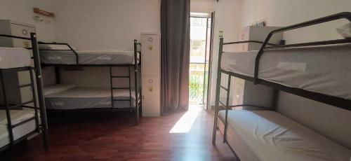 a room with three bunk beds and a window at Alojamientos Cantíber in Santander