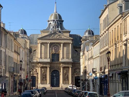 un gran edificio con una torre de reloj en una calle en Appartement Versailles quartier Notre Dame au pied du Chateau avec Parking, en Versalles