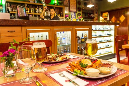 a table with two glasses of beer and food at Saint George Hotel & Medical Spa in Pomorie