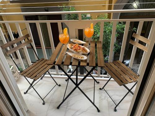 a table with two chairs and a plate of food on a balcony at Donn'Anna Naples City Center in Naples