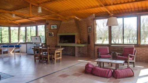 sala de estar con mesas, sillas y chimenea en Yerba Buena casas de campo - Nono, en Nono