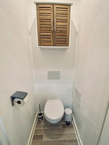 La petite salle de bains est pourvue de toilettes et d'une armoire en bois. dans l'établissement CAUVI - Antibes Centre, WIFI, Climatisation, 4 personnes, à Antibes
