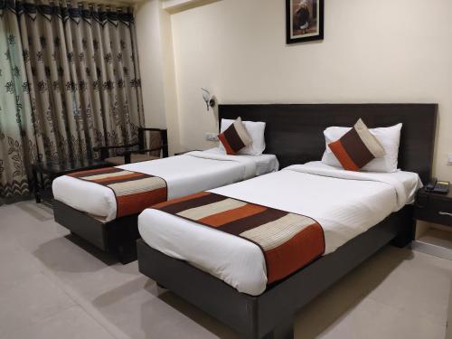 a couple of beds in a room withskirts at Hotel City Square By KeyMagics in Jodhpur