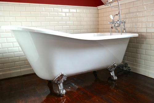 a white bath tub with a faucet in a bathroom at Alte Schreinerei Boutique Hotel in Cologne