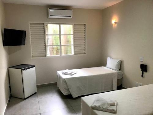 a small room with a bed and a window at AVARE PLAZA SLIM in Avaré