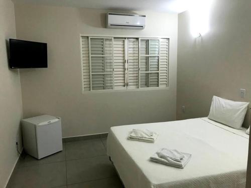 a bedroom with a bed with two towels on it at AVARE PLAZA SLIM in Avaré