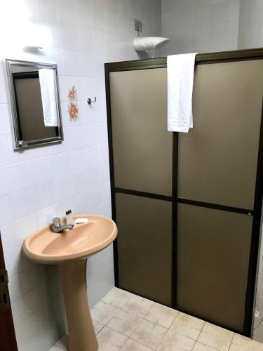La salle de bains est pourvue d'un lavabo et d'une porte coulissante. dans l'établissement AVARE PLAZA SLIM, à Avaré