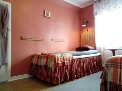 ウッラレッドにあるUllaredsgården B&Bの赤い壁のベッドルーム1室(ベッド2台付)