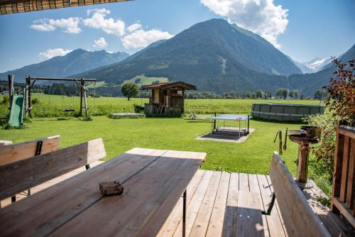 a picnic table in a field with mountains in the background at Gästehaus Dreier in Neukirchen am Großvenediger