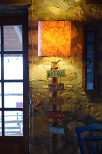 a light on a wall with street signs on it at Arli House in Ano Trikala