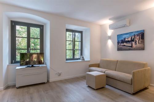 a living room with a couch and a tv at Residence La Torre con private park in Trieste