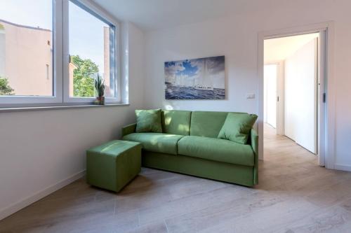 a green couch in a living room with a window at Residence La Torre con private park in Trieste