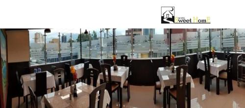 a restaurant with tables and chairs and a view of a city at Hotel Sweet Home in Bogotá