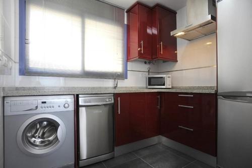 a kitchen with a washing machine and a microwave at Livingtarifa Apartamento Entre Dos Aguas in Tarifa