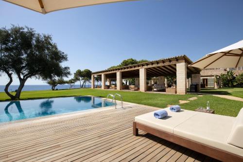 a backyard with a swimming pool and a house at Can Simoneta - Adults Only in Canyamel