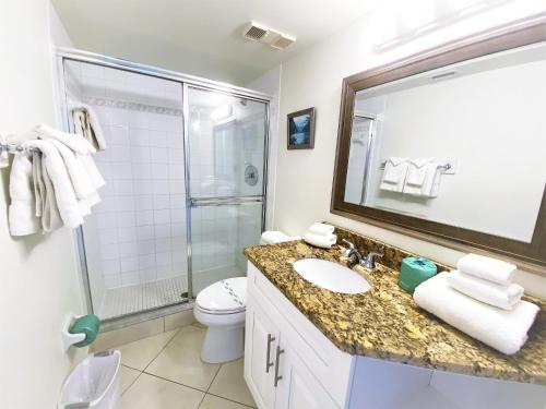 a bathroom with a sink and a shower and a toilet at Sunrise Resort by Liberte' in St Pete Beach