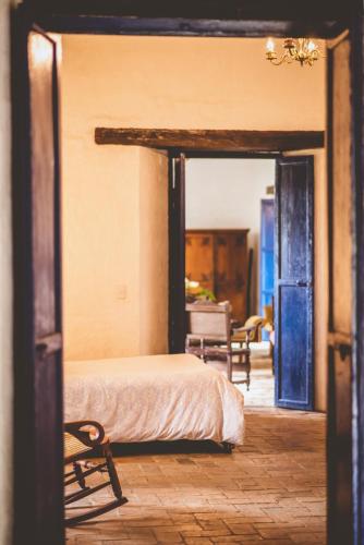 a bedroom with a bed and a open doorway at Hacienda Pisoje in Popayan